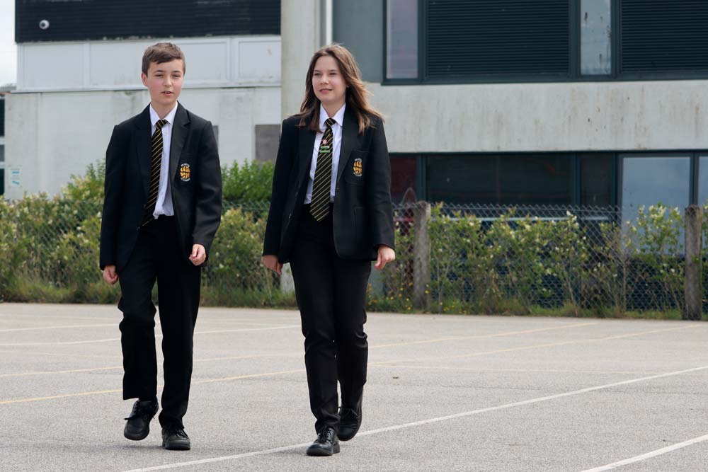 Photo in the Year 7 Yard Boy and Girl in uniform talking in yard